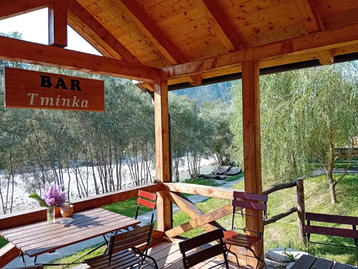 Lesena uta z mizo in klopmi na bregu reke